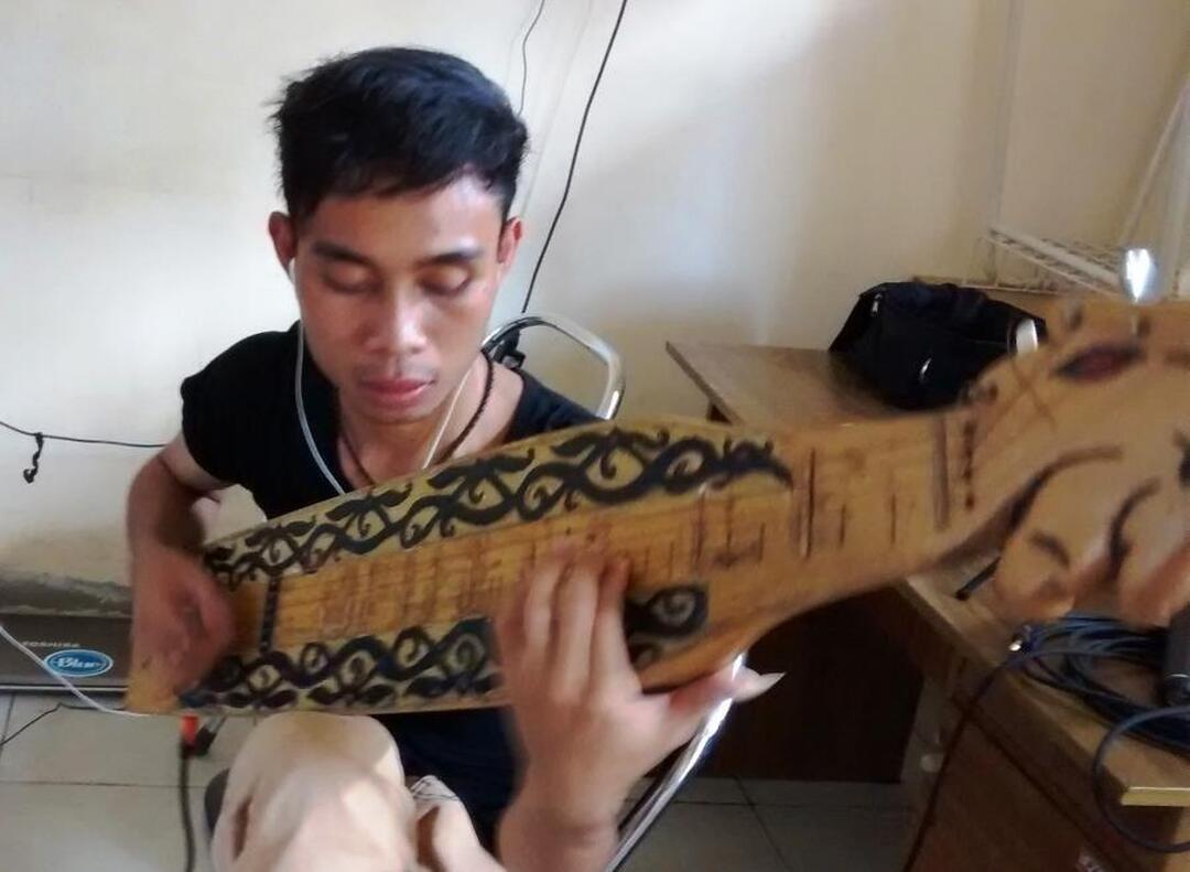 Young Dayakness plays a music instrumen sape Young Dayakness plays a music instrumen sape